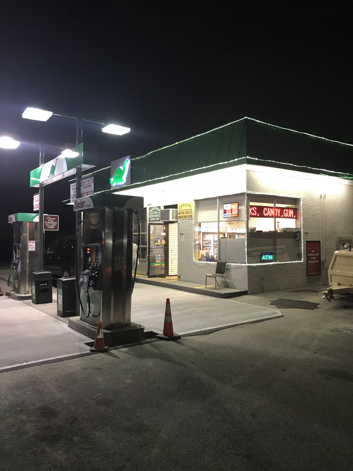 Sinclair pumps and One Broadway Auto storefront at night